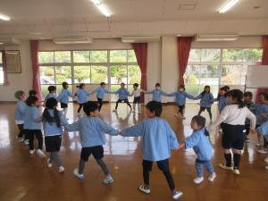幼児が手をつないでダンスをしているところ