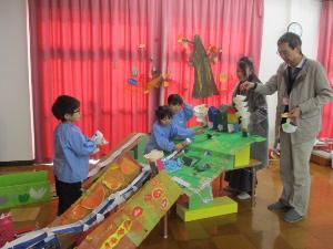 祖父母と一緒にどんぐりを転がして遊んでいる様子