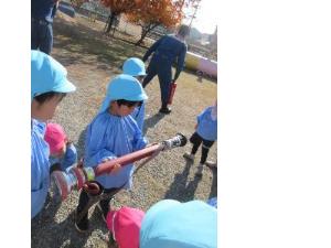 幼児がホースの筒先に触れている様子