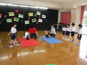 幼児がマットで前転しているところ