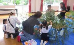 幼児と保護者が七夕飾りを飾る様子