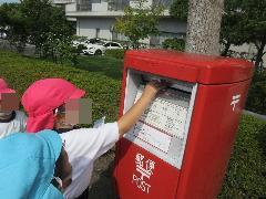 幼児がポストに手紙を投函している様子（1枚目）