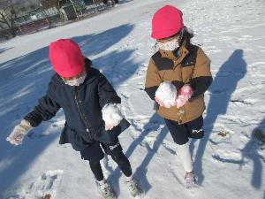 幼児が雪玉を作っているところ