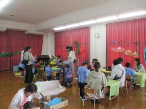 幼児が保護者を招きお店屋さんごっこをしている様子