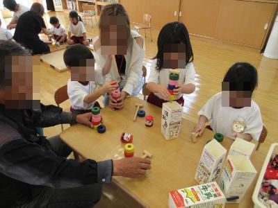 祖父母と伝統遊びをする様子です。