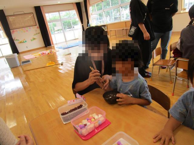 お母さんと一緒に箸を持っています