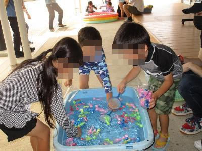 園児たちが金魚すくいをする様子です。