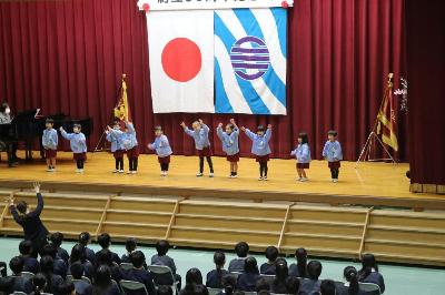 式典で歌とお祝いメッセージを披露する様子です。