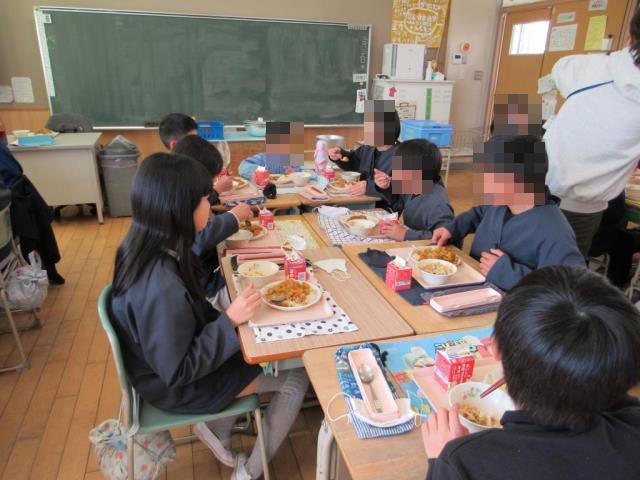 小学生と一緒に給食を食べています
