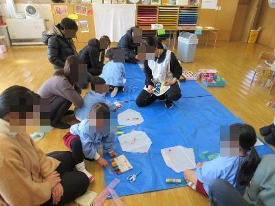 子ども達が保護者と凧を作る様子です。