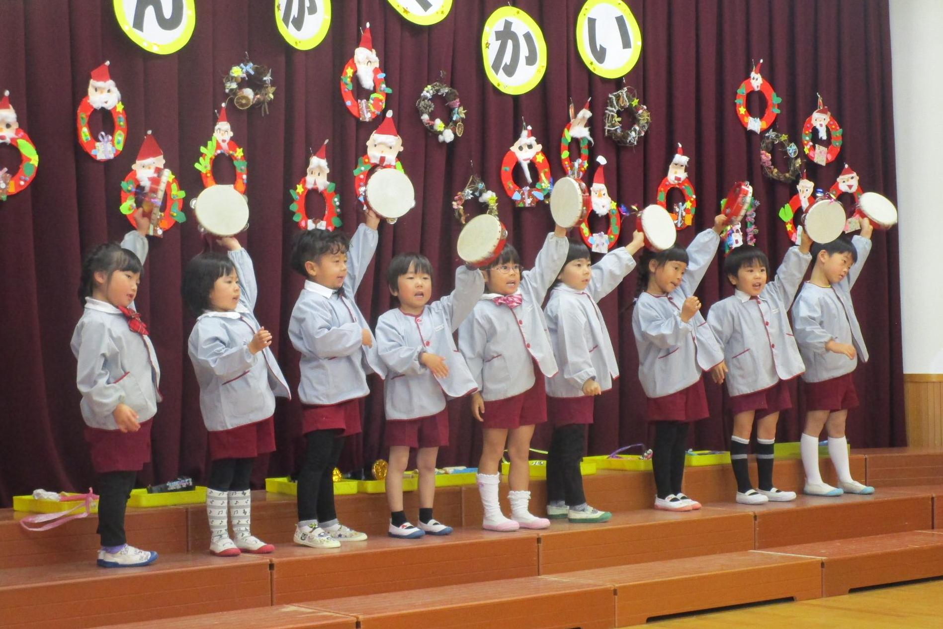 音楽会手をあげてタンバリンを鳴らす