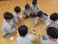 カルタ大会でカルタに手をのばす4歳児