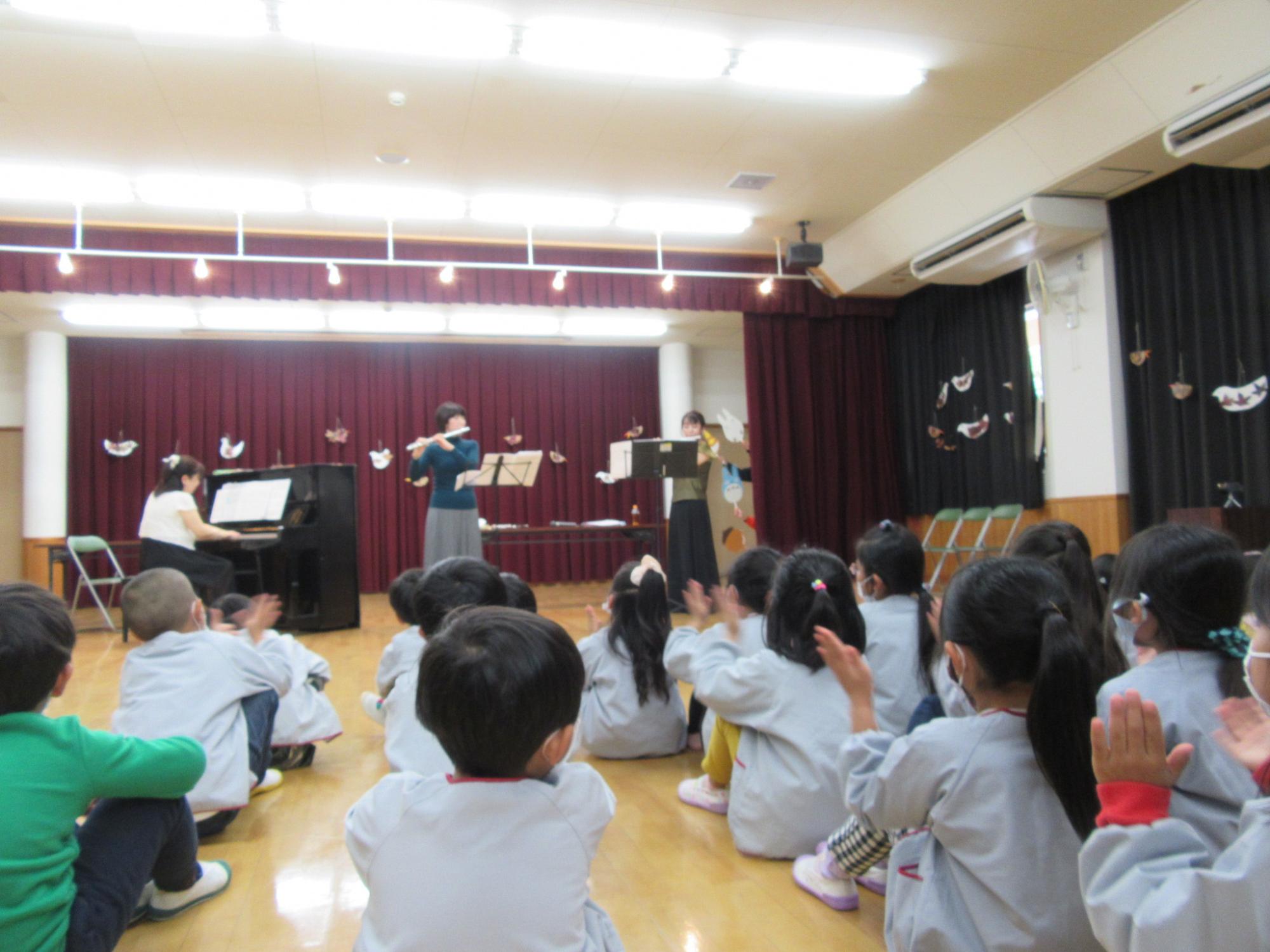 フルートピアノ演奏を聴く子ども達