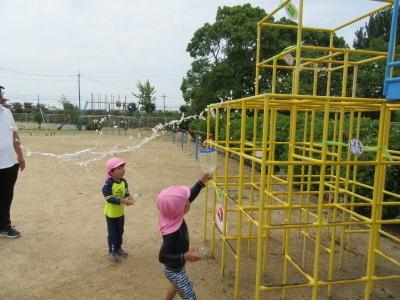 平成31年度1学期やまて幼稚園園庭で持ってきた容器に水を汲み水遊び、的あてしている時の写真