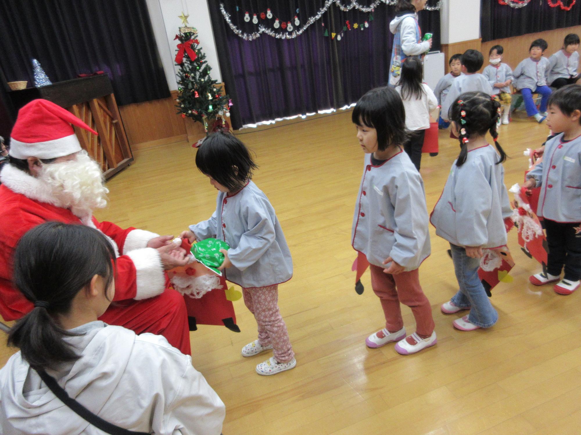 クリスマスプレゼントをもらう園児