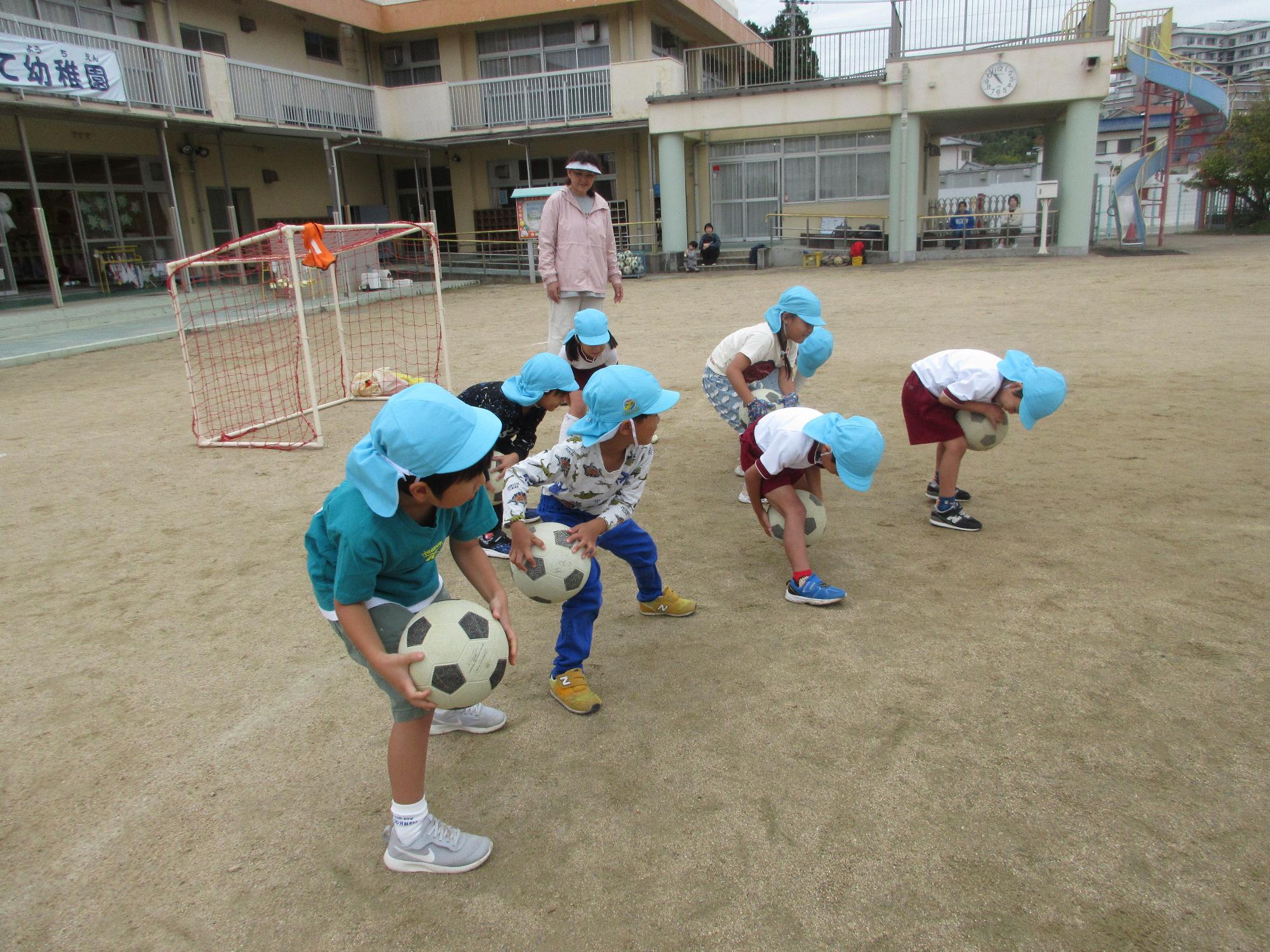 足の周りにサッカーボールを回している