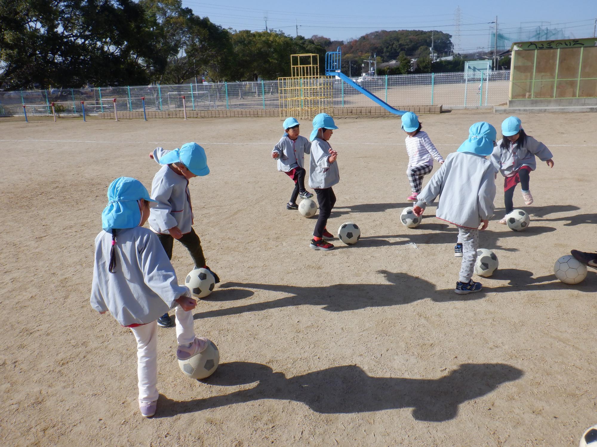 サッカーボールで遊ぶ園児