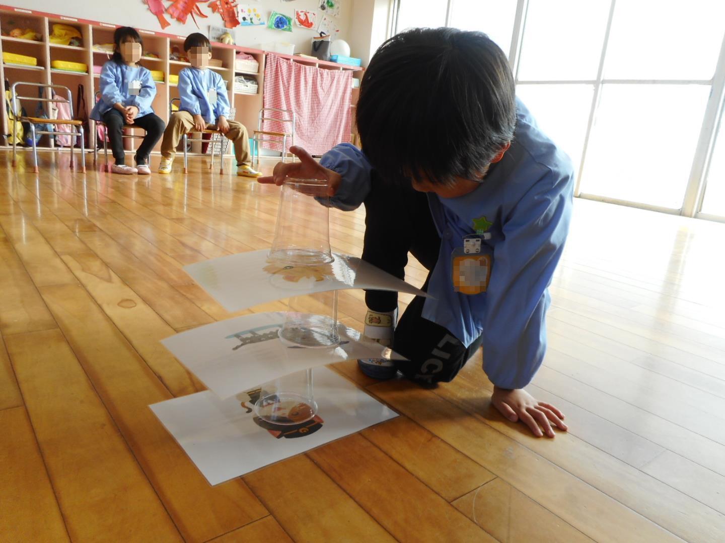 紙コップを積んで遊ぶ年少児