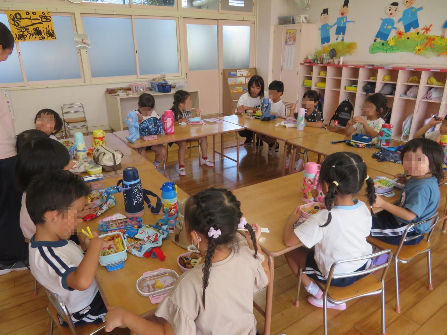 円になってみんなで弁当を食べる4歳児