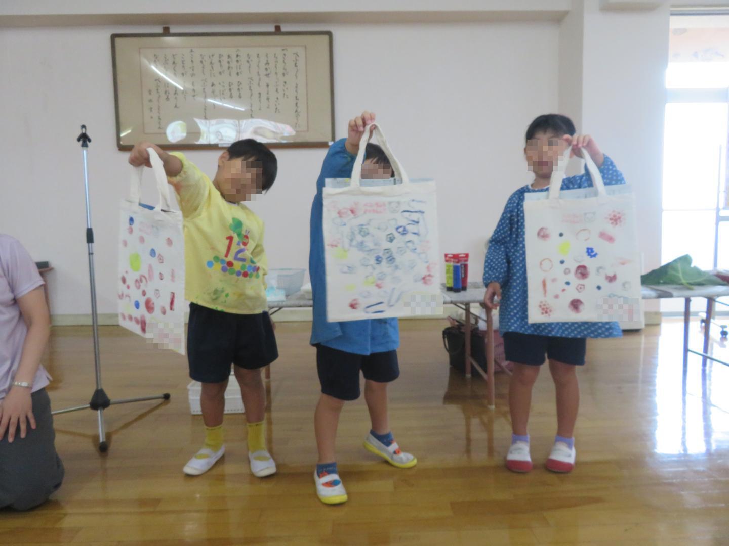 前に出て完成したトートバックを披露する園児