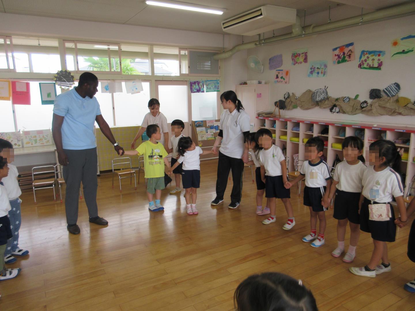 みんなで手を繋いで挨拶ゲームをする幼児