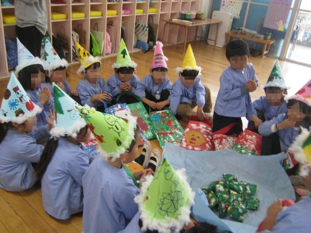 サプライズのプレゼントを開けて驚いている幼児