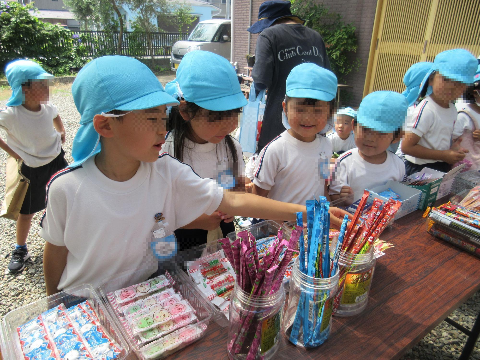 駄菓子屋さんで様子お菓子を選んでいる様子