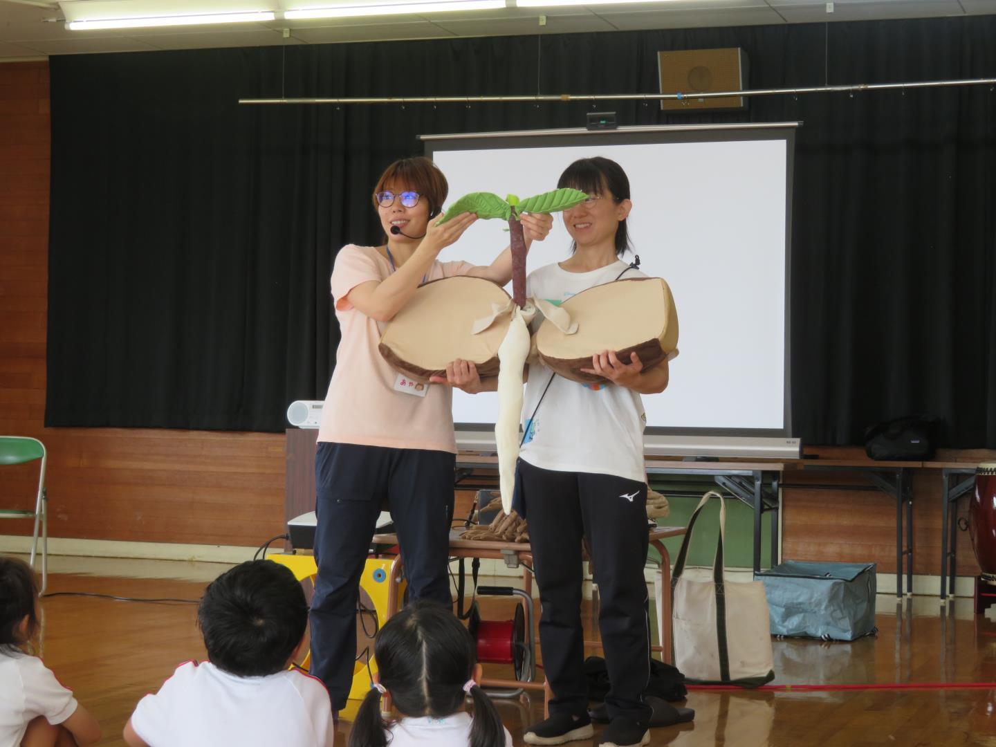 どんぐりが木になることを人形を使って教えていただいている写真です。
