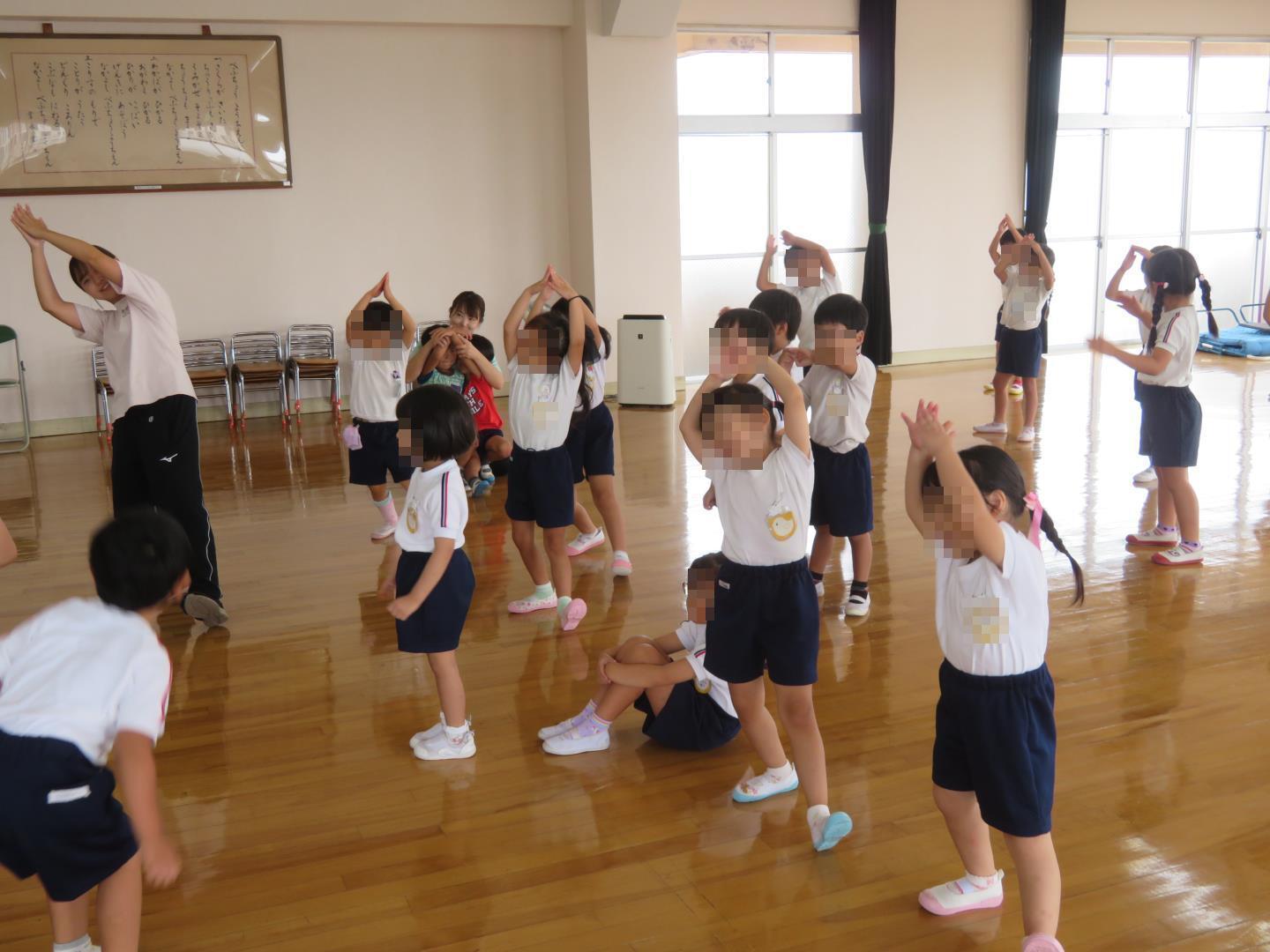 ぐんぐんどんぐりこ体操をみんなで踊っている写真です。