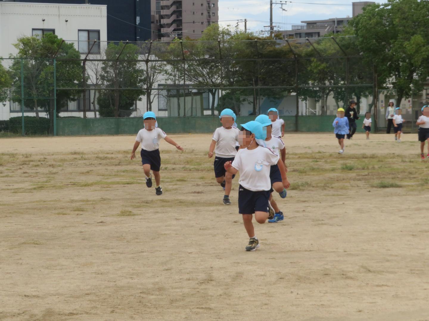 グラウンドの端から端まで走っている園児