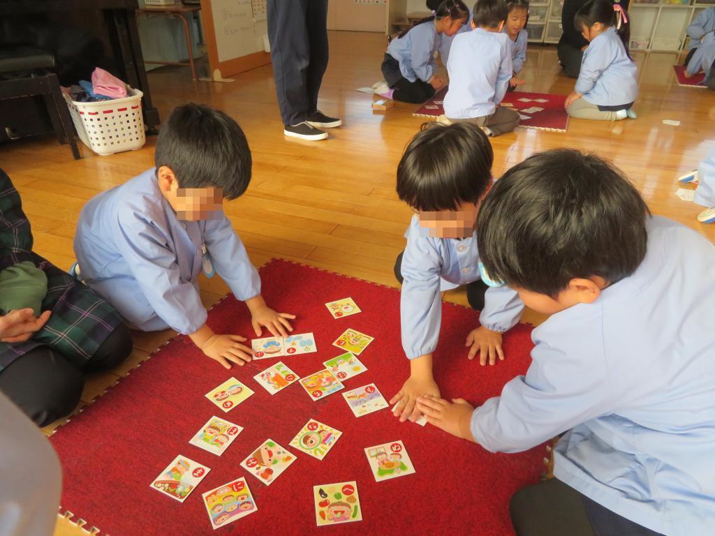 かるたの札を取り合っている年長児