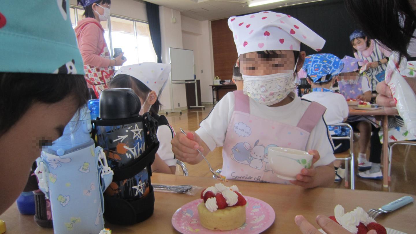 ケーキにチョコスプレーをトッピングする園児