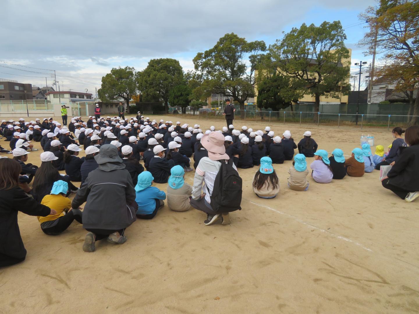 小学校で避難訓練について話を聞いている様子
