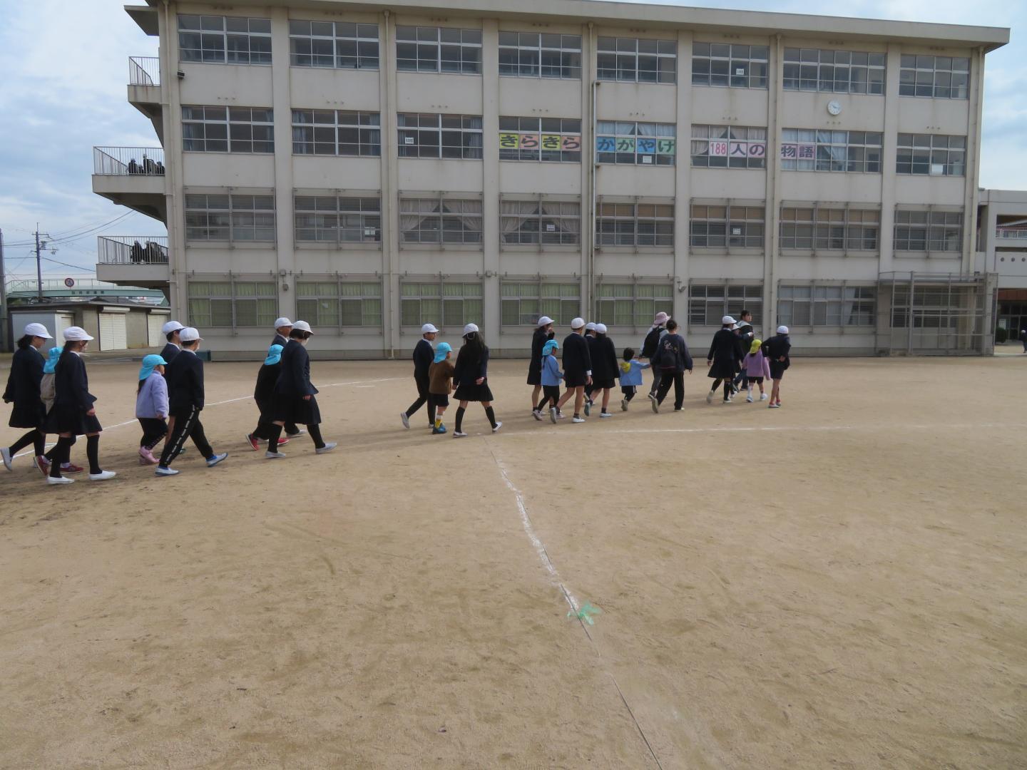 小学生と手を繋いで垂直避難している様子