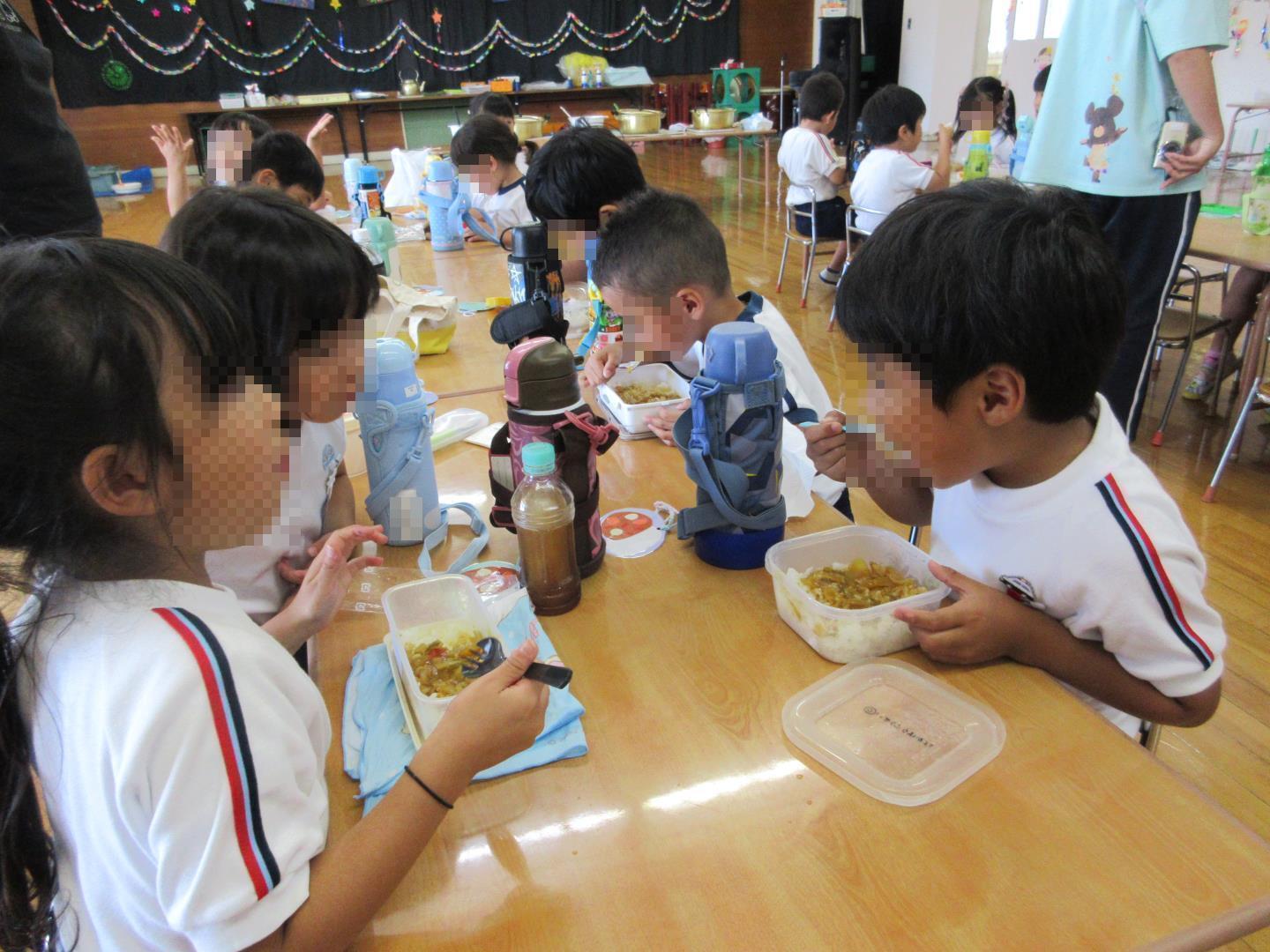 喜んで夏野菜カレーを食べている園児