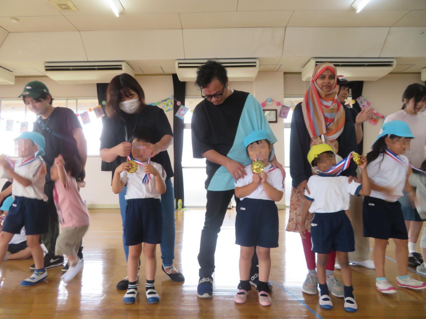 保護者からメダルをもらう園児の様子