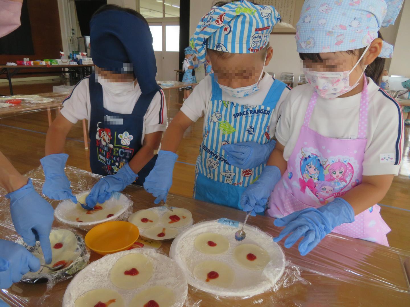 餃子の皮にケチャップを塗る園児