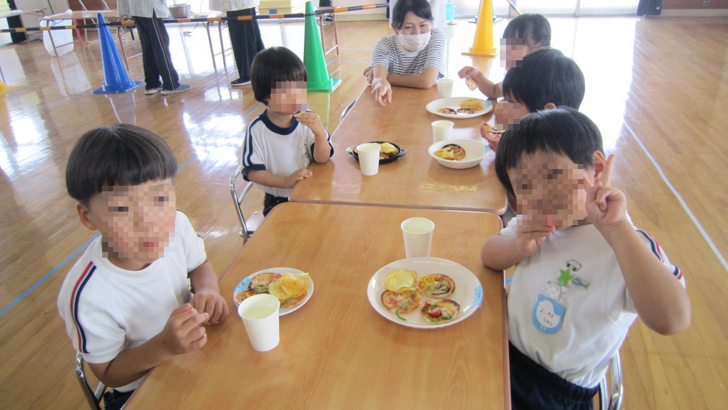 喜んでピザを食べている園児