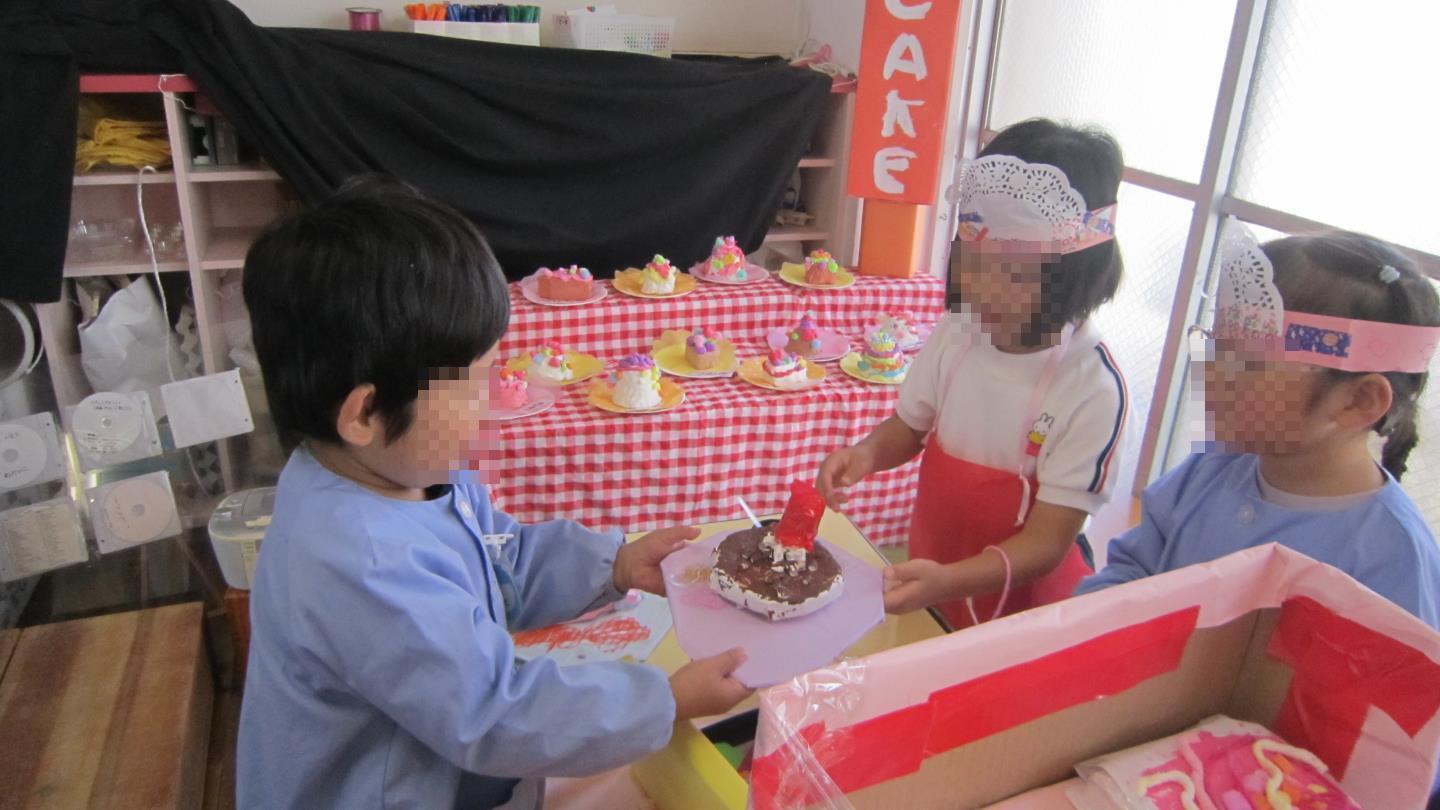 ケーキ屋さんで店員さんとお客さんになりきって遊ぶ園児。