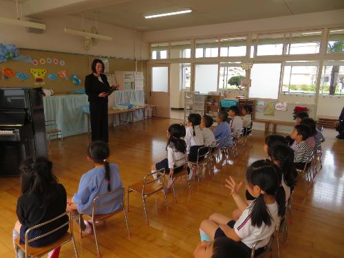 年長児が進級式に参加し、園長先生のお話を聞いている様子