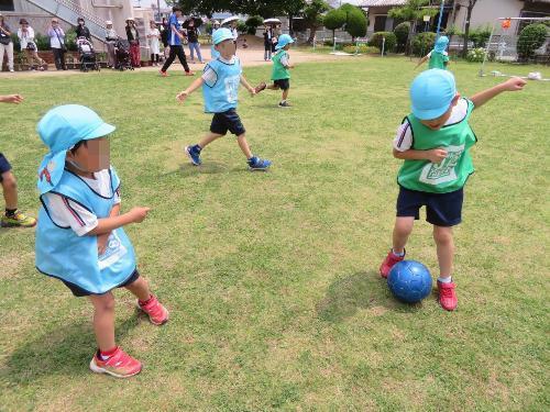 友達と一つのサッカーボールを追いかけている様子