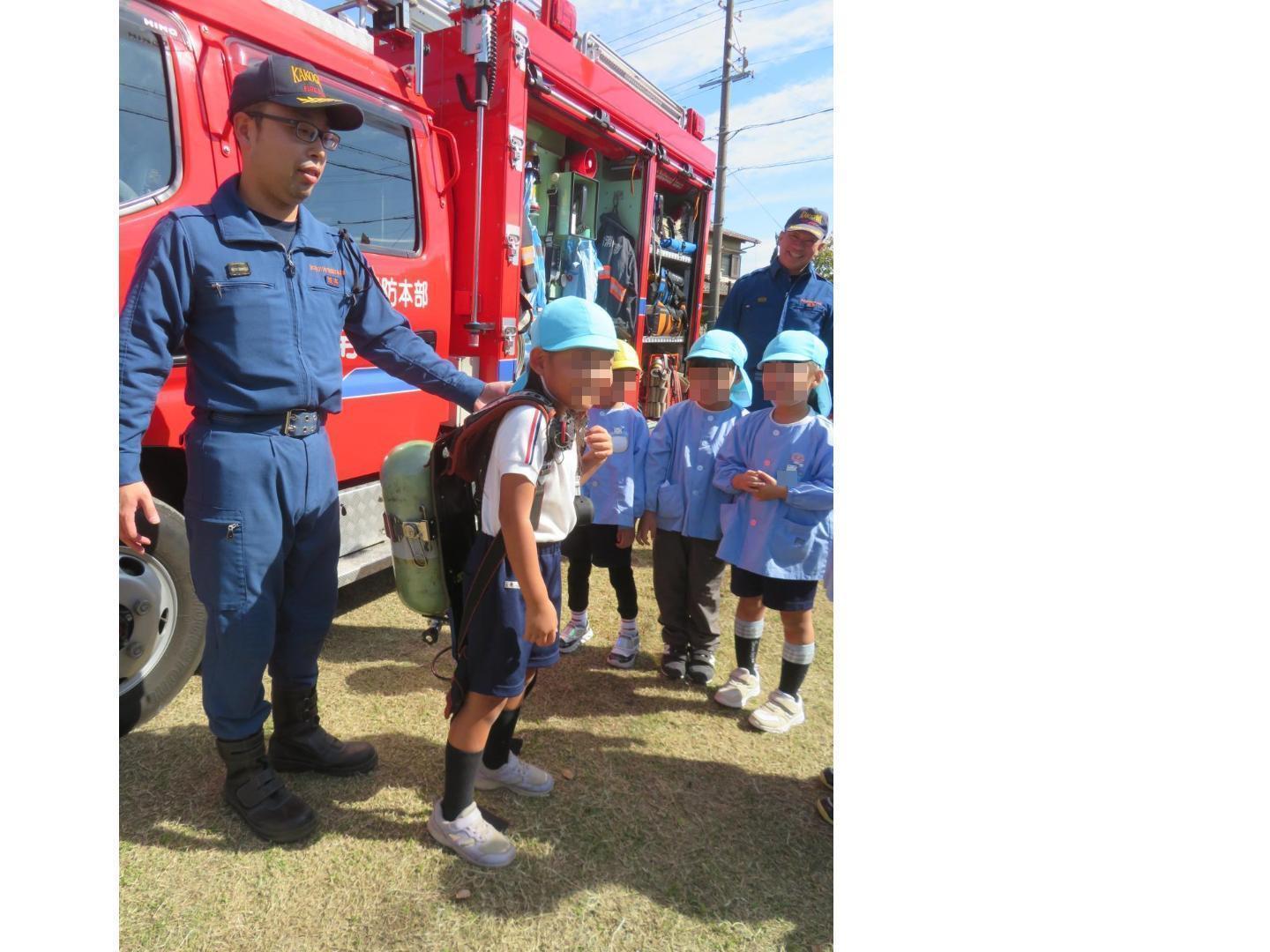 酸素ボンベを背負う体験をしているところ