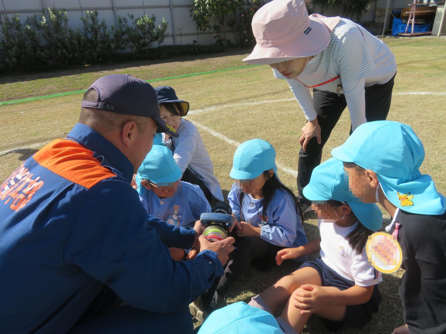 ホースの噴射口を触らせて頂いている園児