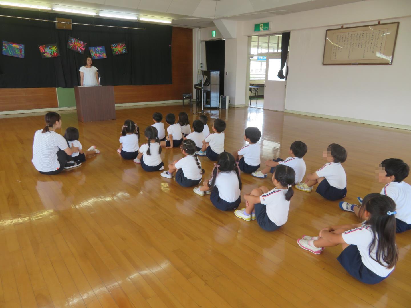 終業式で園長先生のお話を聞く園児