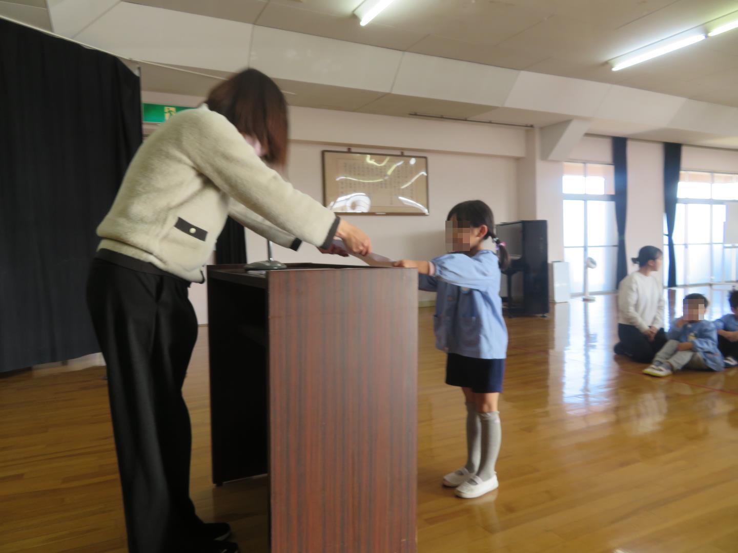 園長先生から表彰状を受け取る幼児