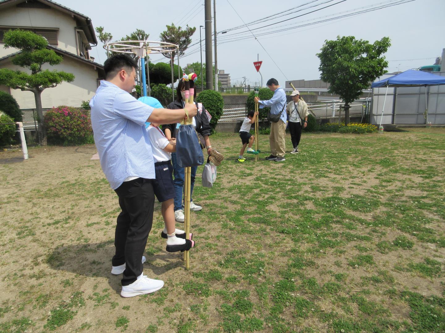 親子で竹馬に挑戦する園児