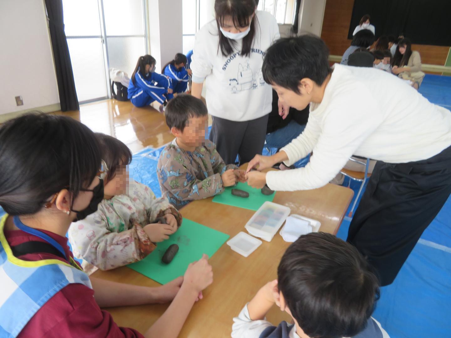 陶芸の先生に作り方のコツを教えてもらっているところ