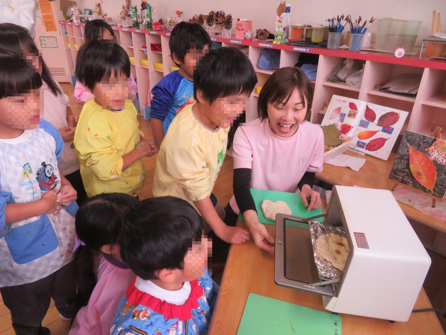 自分達で作った小麦粉粘土が焼きあがったのを見ているところ