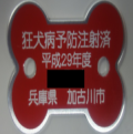 「狂犬病予防注射済平成29年度兵庫県加古川市」と書かれた赤色の骨の形をした札の写真