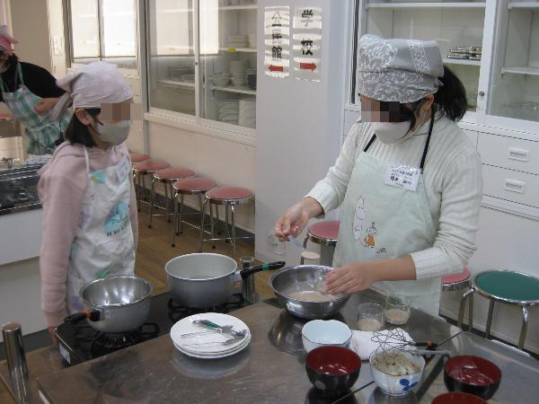 プリンの生地をカップに入れている様子